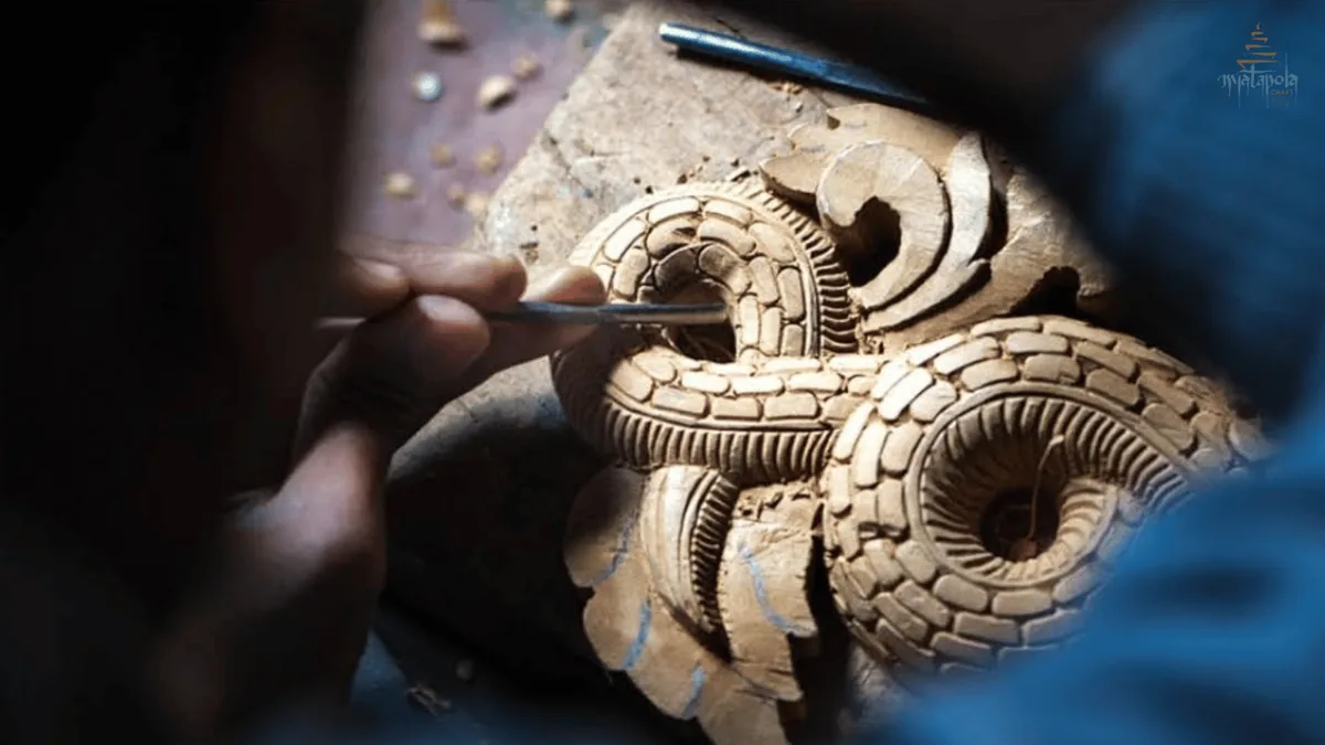 An artisan hand carving wood with a chisel